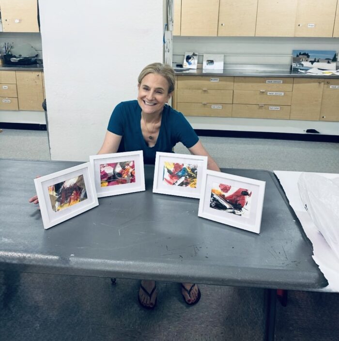 The artist, Ruth, with 4 of her art pieces. Singlehandedly creating. Unhiding through art, one canvas at a time.
