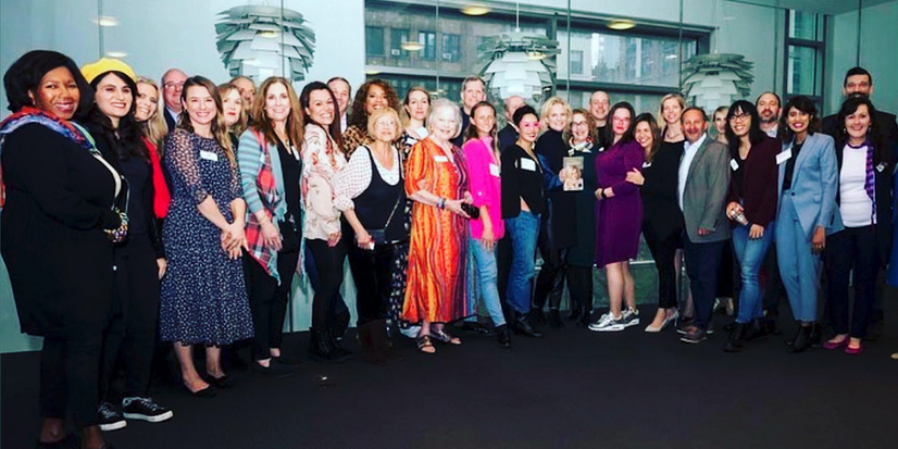Group photo of people standing together at an NSA-NYC event, smiling toward the camera. Photo credit: John DeMato