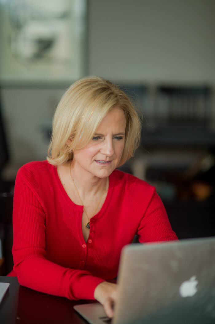 Ruth Rathblott sitting at a laptop. Photo: Maggie Marguerite Studio.