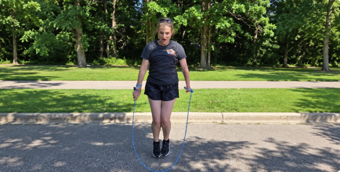 Jumpin Rope Me jumping rope outdoors using an EazyHold wristband, with both feet off the ground.