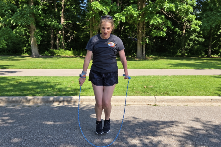 Me jumping rope outdoors using an EazyHold wristband, with both feet off the ground.