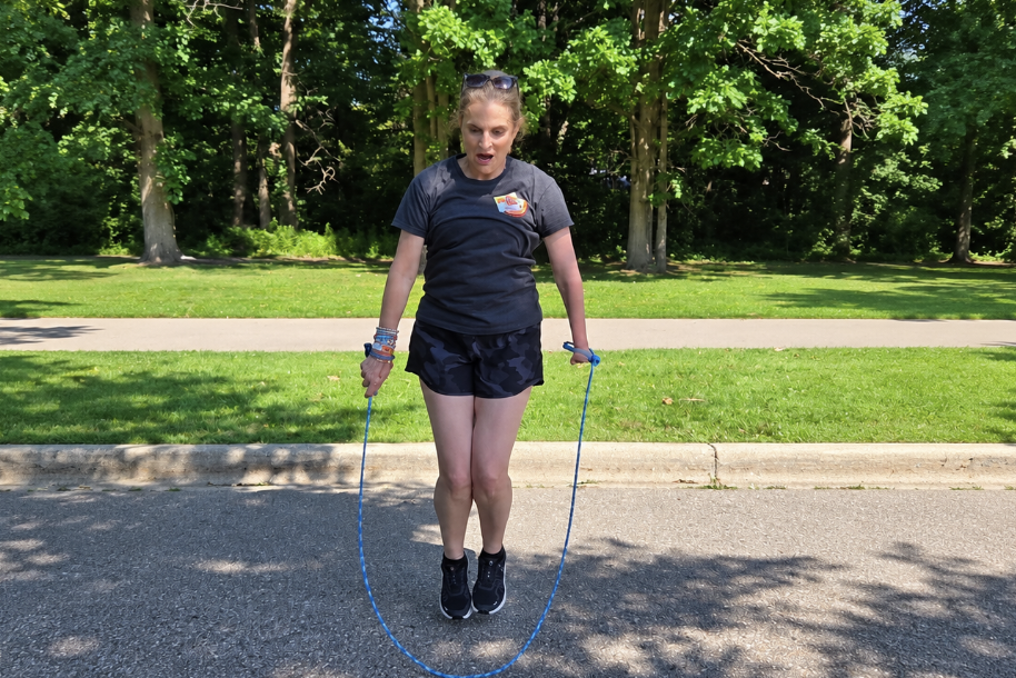 Me jumping rope outdoors using an EazyHold wristband, with both feet off the ground.